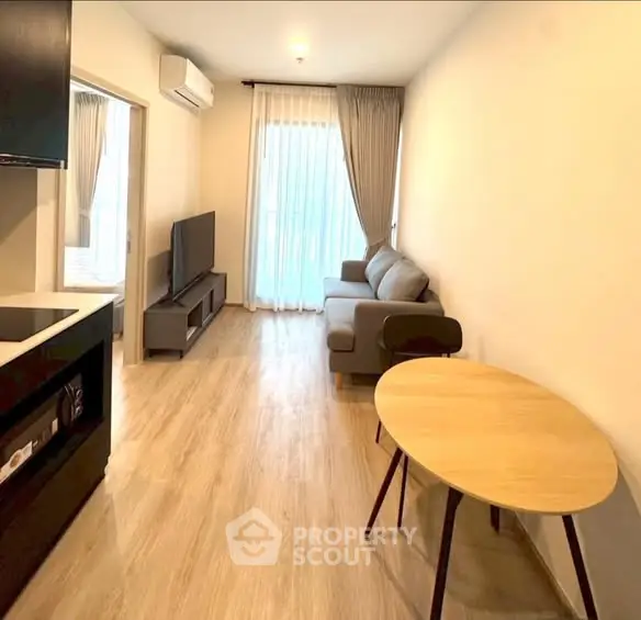 Modern living room with sleek design and natural light, featuring a cozy sofa and stylish dining area.