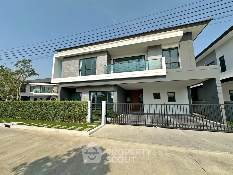 Modern two-story house with sleek design and spacious balcony in a serene neighborhood.