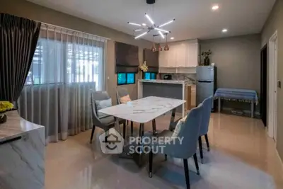 Modern dining area with elegant marble table and stylish lighting in open layout kitchen.