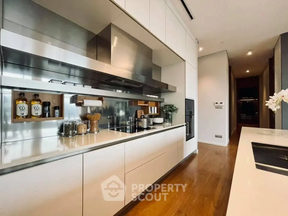 Modern kitchen with sleek cabinetry and stainless steel appliances in a luxury apartment.