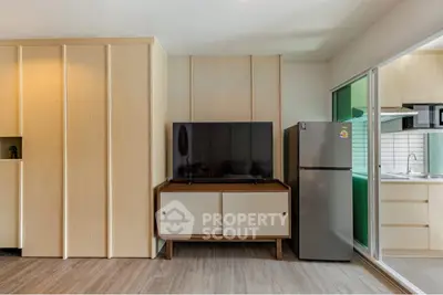 Modern living room with sleek TV setup and adjacent kitchen area.