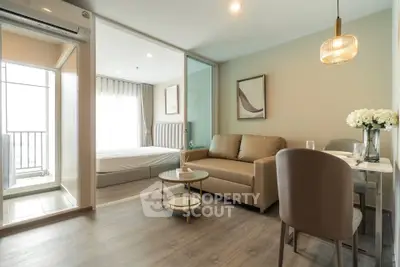 Modern open-plan living room with cozy sofa and dining area, leading to a bright bedroom with balcony.