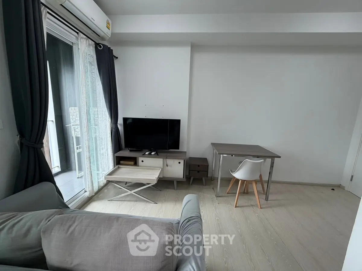 Modern living room with sleek furniture and balcony access