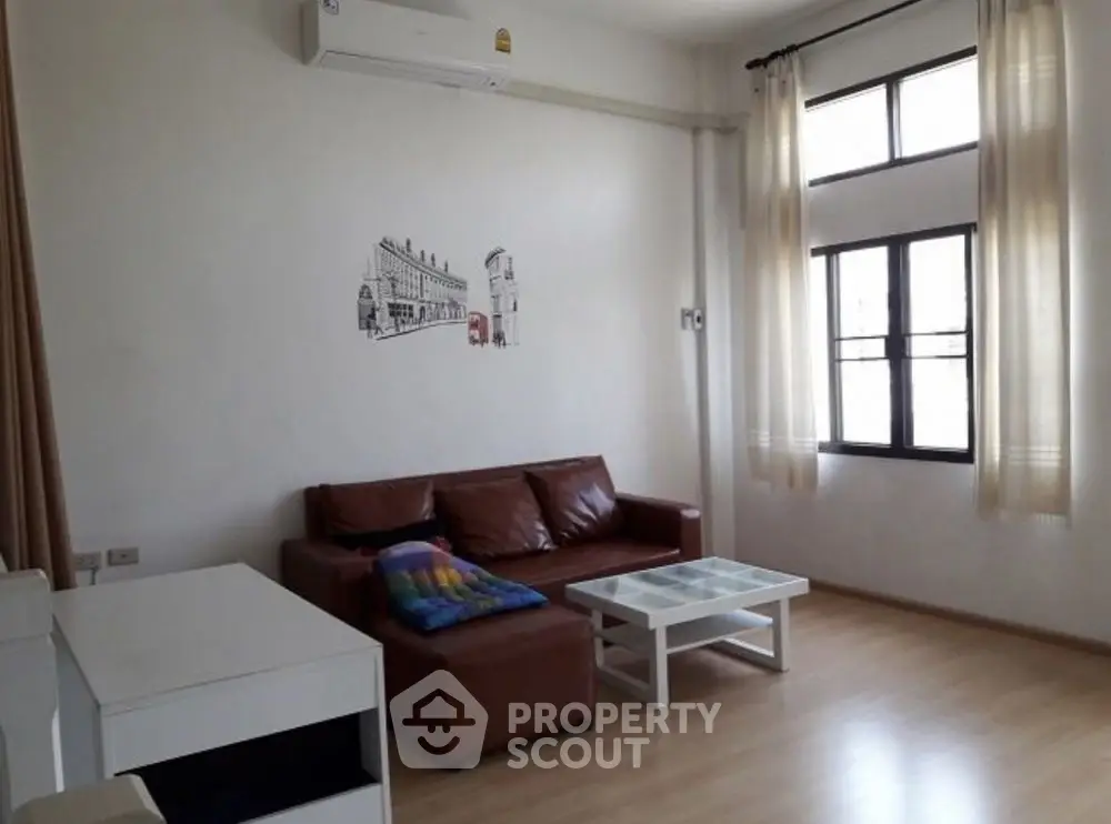 Modern living room with brown leather sofa and large windows