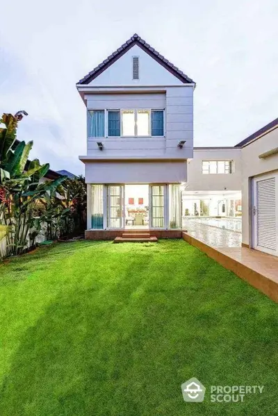 Stunning modern house with lush green lawn and poolside view