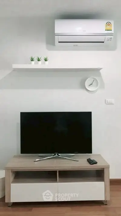 Modern living room with sleek TV setup and air conditioning unit.