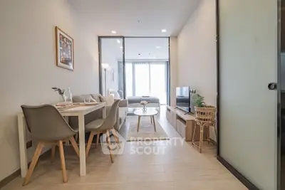 Modern living room with dining area and stylish decor in open layout apartment.