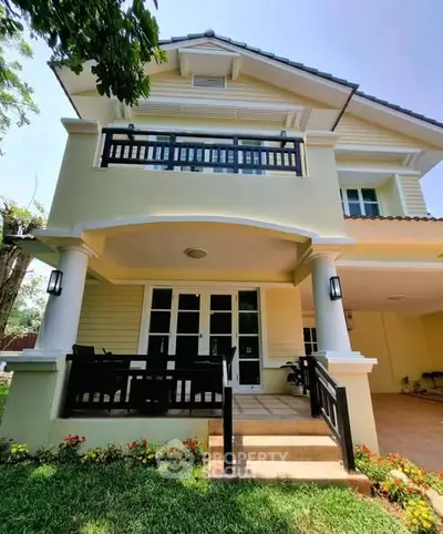 Charming two-story house with balcony and lush garden, perfect for family living.