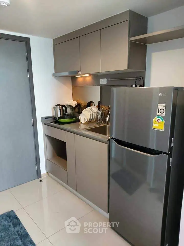 Modern compact kitchen with sleek cabinets and stainless steel fridge