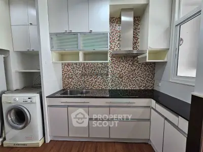 Modern kitchen with sleek cabinets and washing machine