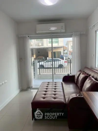 Modern living room with leather sofa and large window view