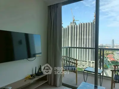 Modern living room with balcony and city view, featuring sleek TV and stylish furniture.