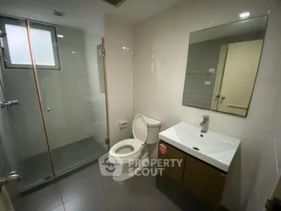 Modern bathroom with glass shower and sleek vanity in a contemporary home.