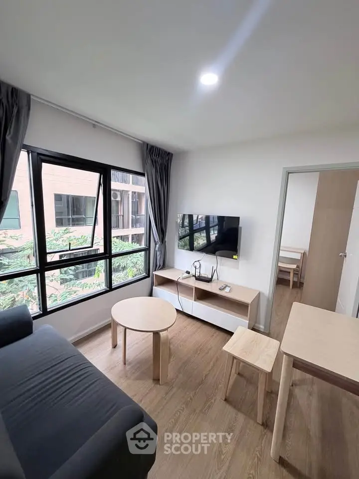 Modern living room with large window and stylish furniture in a contemporary apartment.