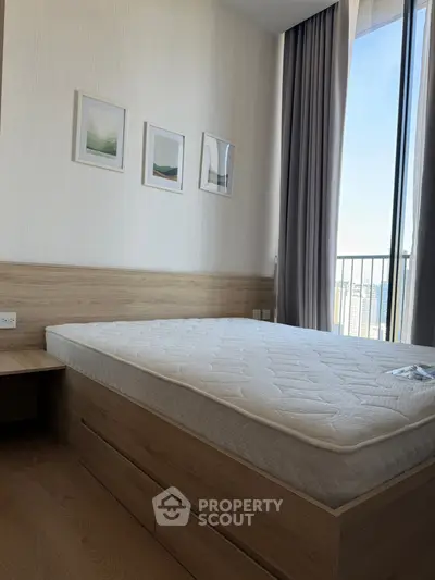 Modern bedroom with wooden flooring and balcony view