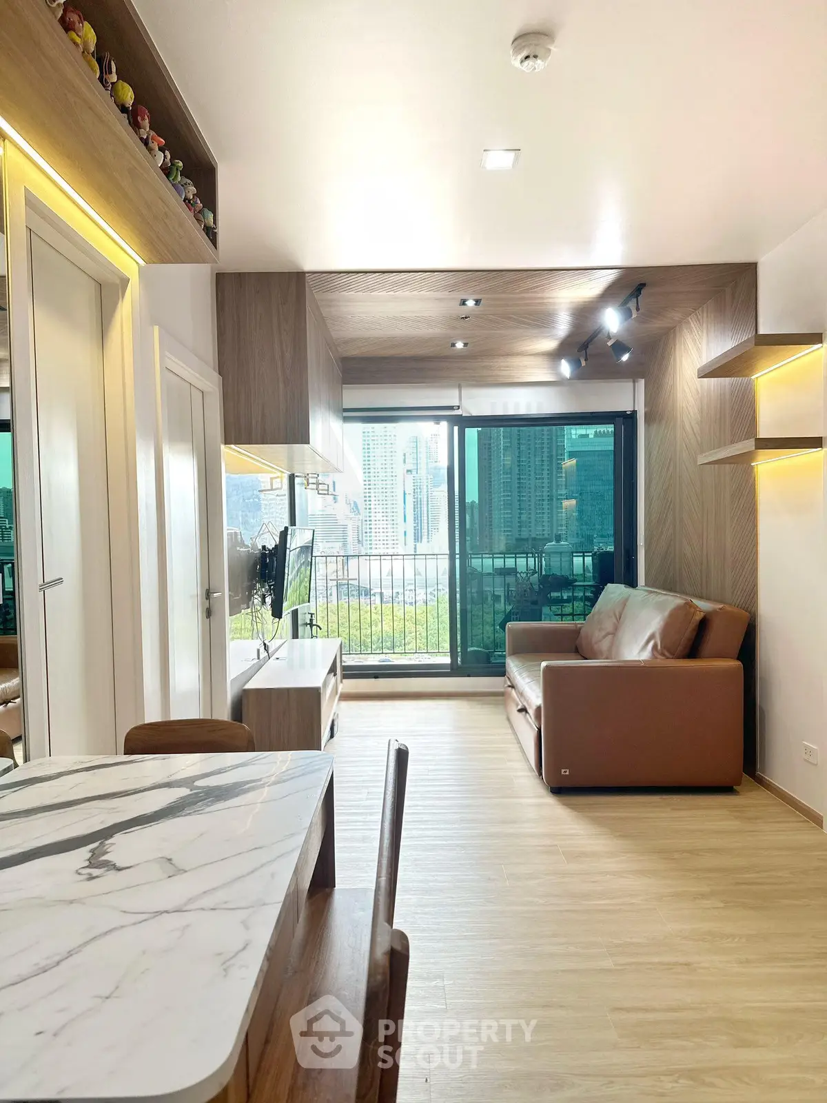 Modern living room with city view, stylish furniture, and natural light.
