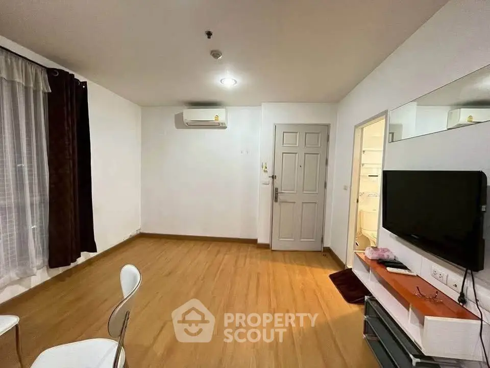 Spacious living room with modern decor and wall-mounted TV, perfect for relaxation and entertainment.