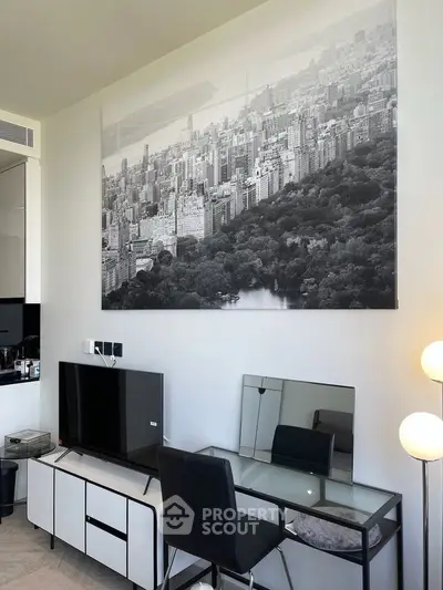 Modern living room with sleek furniture and cityscape artwork, featuring a TV and stylish desk setup.