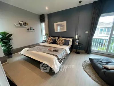 Modern bedroom with stylish decor and large windows offering natural light.