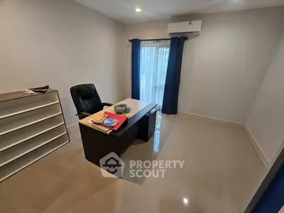 Spacious study room with modern desk and chair, featuring natural light and air conditioning.