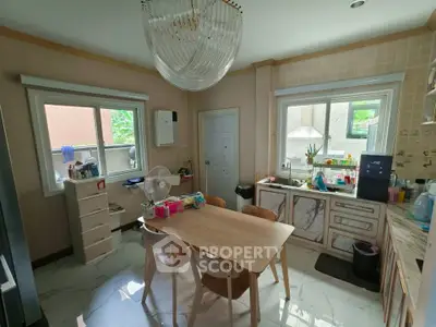 Charming kitchen with modern dining set and ample natural light, perfect for family gatherings.