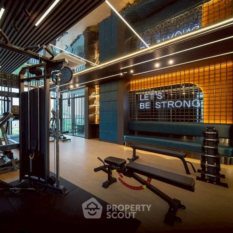 Modern gym with state-of-the-art equipment and motivational decor in luxury building.