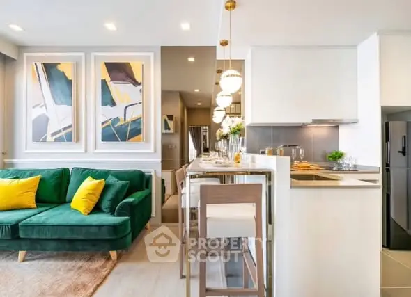 Modern open-plan living room and kitchen with stylish decor and vibrant green sofa.