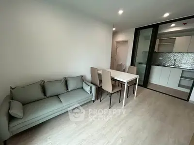 Modern living room with sleek furniture and open kitchen layout in a stylish apartment.