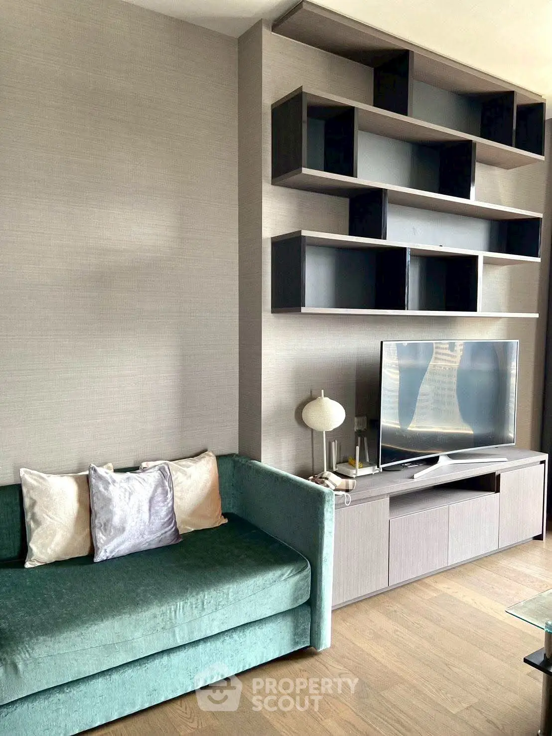 Modern living room with stylish shelving and cozy green sofa