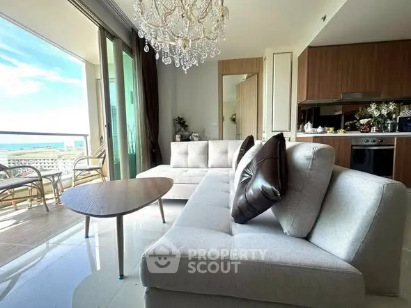 Luxurious living room with ocean view, modern furniture, and elegant chandelier.