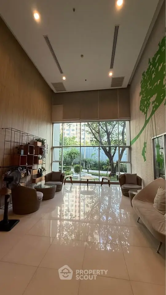 Spacious modern lobby with large windows and stylish seating, offering a serene garden view.