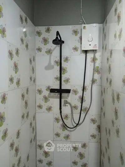 Compact bathroom with floral tiles and modern shower unit