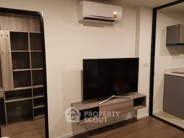 Modern living room with wall-mounted TV and air conditioning in stylish apartment.
