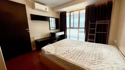 Cozy bedroom with large window and modern furnishings in a stylish apartment.