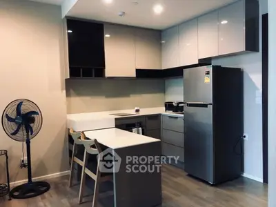 Modern kitchen with sleek cabinets and stainless steel appliances in a cozy apartment.