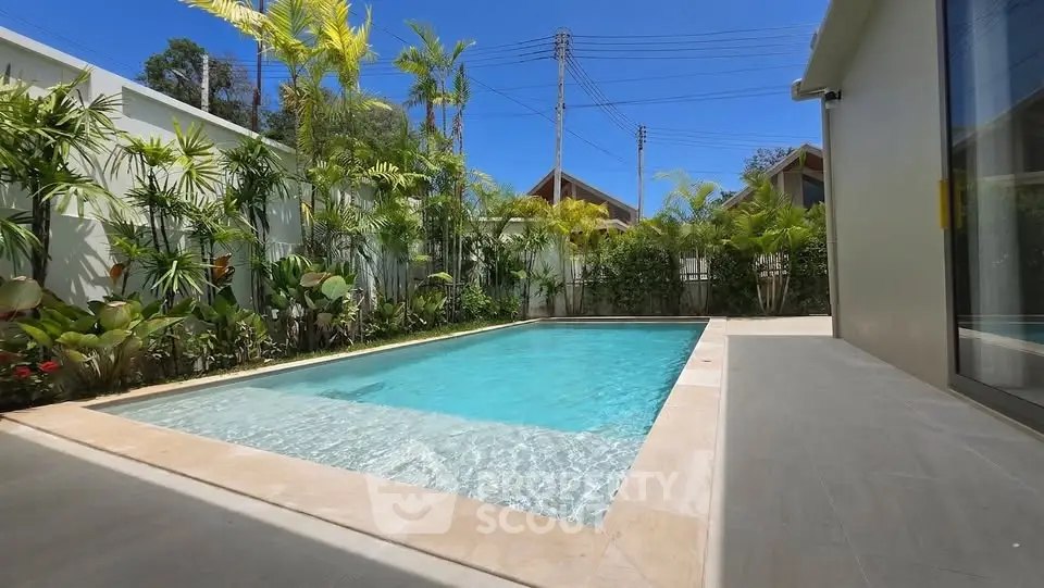 Luxurious private pool surrounded by lush greenery in a modern villa setting.