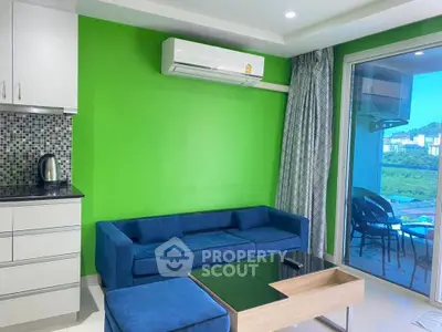 Modern living room with vibrant green wall, blue sofa, and balcony view.