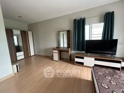 Spacious bedroom with modern furniture and large window for natural light.