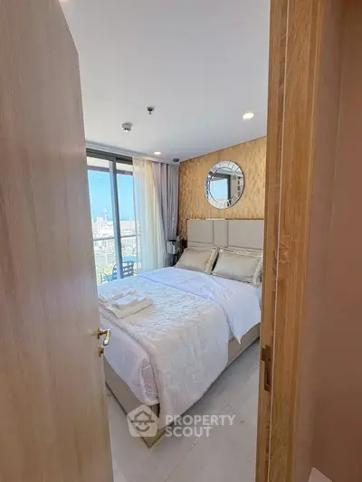 Luxurious bedroom with city view, elegant decor, and plush bedding in modern apartment.