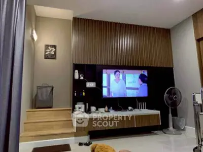Modern living room with TV, stylish decor, and cozy atmosphere.