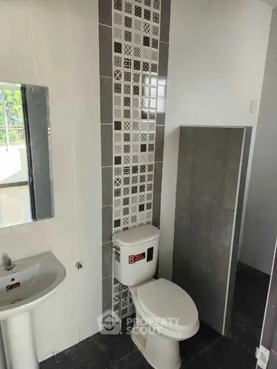 Modern bathroom with stylish tile design and compact fixtures.