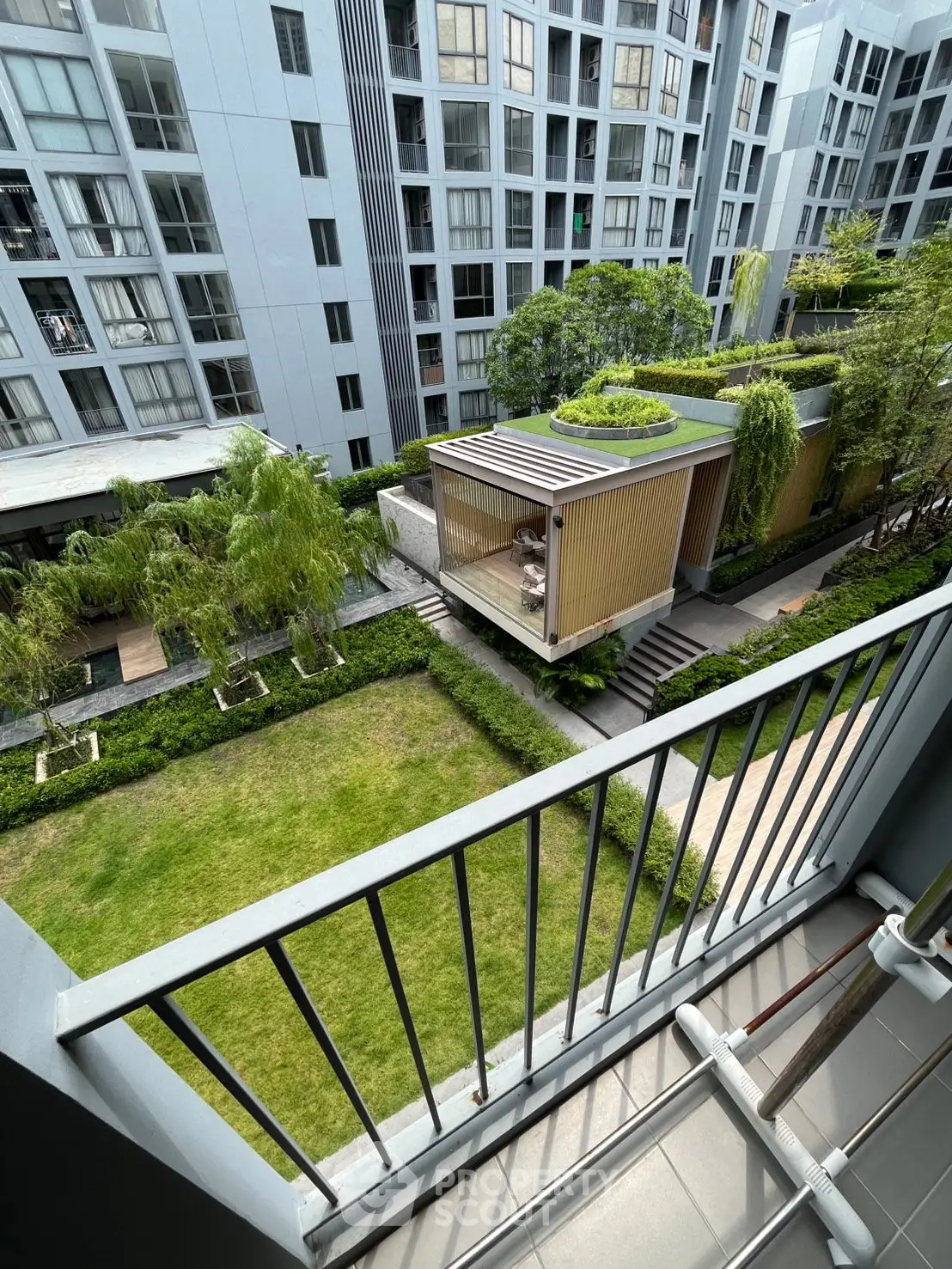 Modern apartment balcony view overlooking lush garden and contemporary architecture