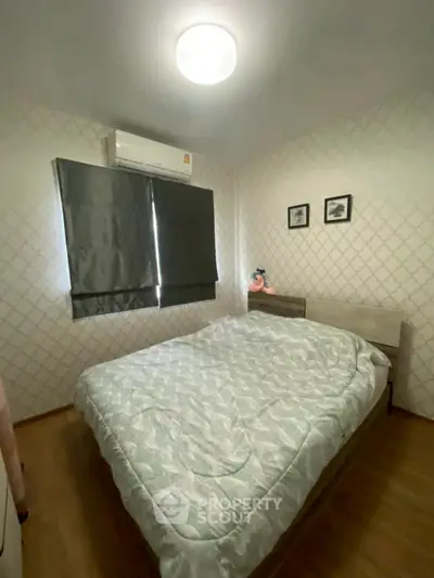 Cozy bedroom with modern decor and air conditioning, perfect for relaxation.