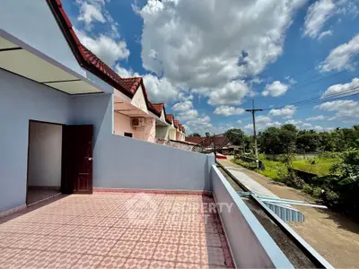 Spacious balcony with scenic view in a row of charming townhouses under a clear blue sky.