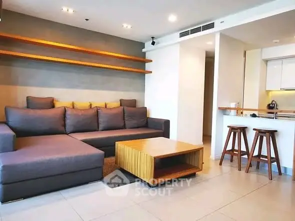 Modern living room with stylish furniture and open kitchen layout in a contemporary apartment.