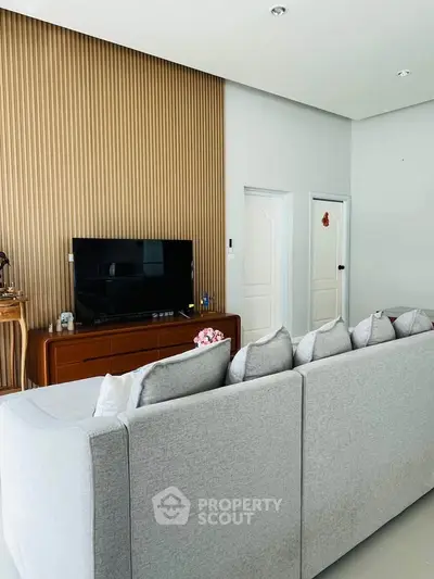 Modern living room with stylish gray sofa and wooden accent wall
