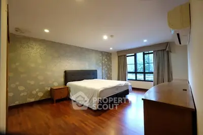 Spacious bedroom with elegant wallpaper and large window view