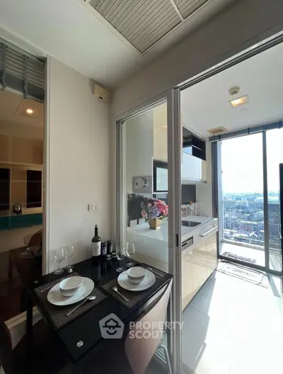 Modern kitchen with open layout and dining area, featuring city view and elegant decor.