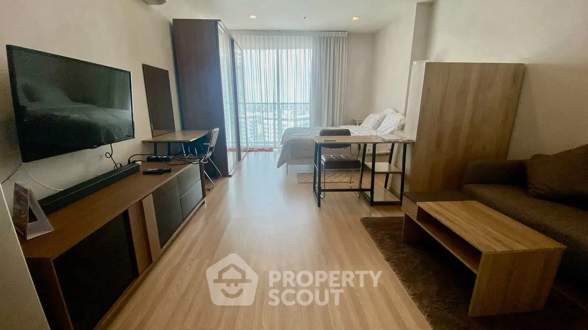 Modern studio apartment with wooden flooring and natural light