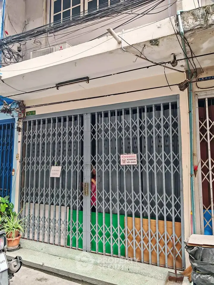 Charming urban storefront with secure metal gate, ideal for small business or retail space in bustling neighborhood.